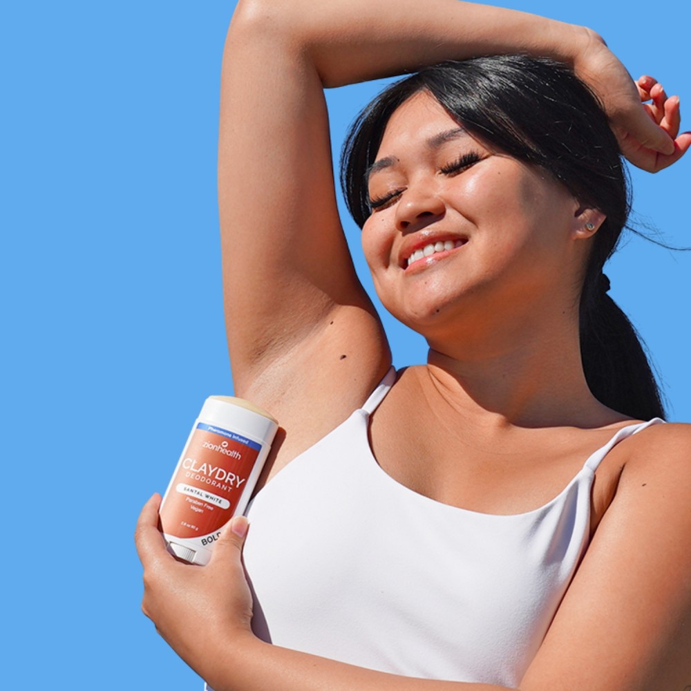 Person happily applying CLAYDRY deodorant